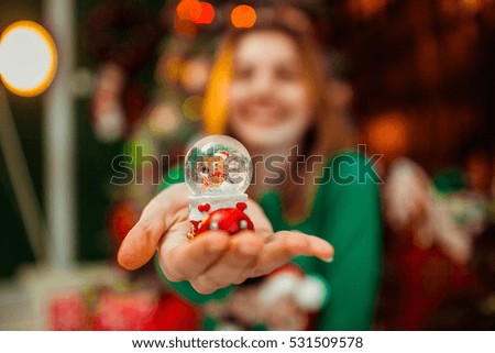 beautiful glass Christmas toy with snow inside in female hands