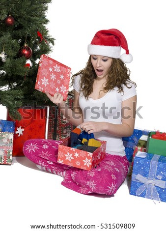 Teen by the christmas tree opening gifts on christmas morning image isolated on white background