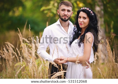 Beautiful young happy couple is walking in the field.