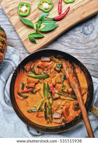 Butternut squash/ pumpkin in authentic Thai red curry coconut sauce with red and green chilies. Serve with grilled cashew nut in a butternut squash bowl.  Royalty-Free Stock Photo #531515938