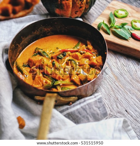 Butternut squash/ pumpkin in authentic Thai red curry coconut sauce with red and green chilies. Serve with grilled cashew nut in a butternut squash bowl.  Royalty-Free Stock Photo #531515950