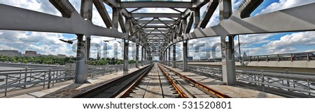 Moscow centre / Railway bridge, Moscow circle line. Hard metal construction. Super wide-angle panorama photography. Panoramic landscape. Large railroad building. Perspective lines, geometry. Blue sky