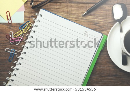 Notebook and Office Supplies on a Wooden Table