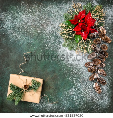 Christmas decoration with red flowers and wrapped gifts. Holidays background. Vintage style toned picture