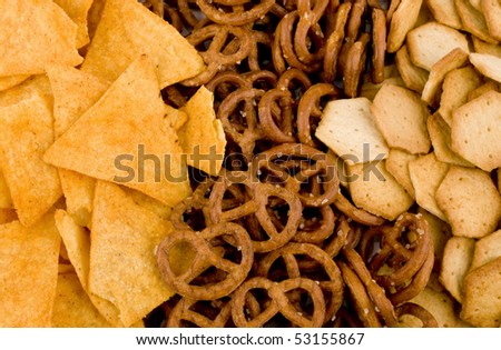Closeup picture of tortilla chips, pretzels and spicy crackers