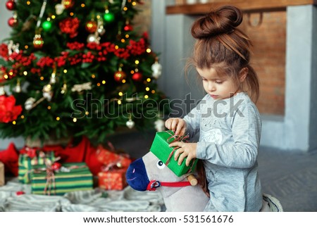little kid opens a gift. The concept of Christmas.