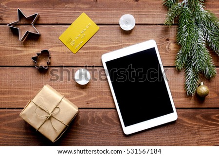 online shopping christmas with e-tablet wooden background top view