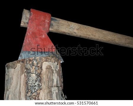 Old axe stuck in log isolated over black background