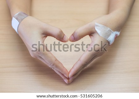 Patients hands forming heart shape on top table.