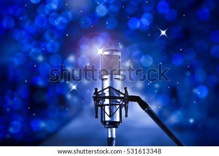 Condenser microphone with blue bokeh background.High quality microphone standing on  karaoke stage ready for joyful christmas party and celebration.