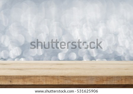 Wood table top on abstract white bokeh, Christmas concept.
