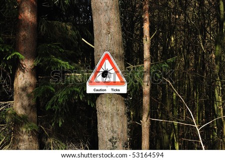 A warning sign referable ticks in wood. Royalty-Free Stock Photo #53164594