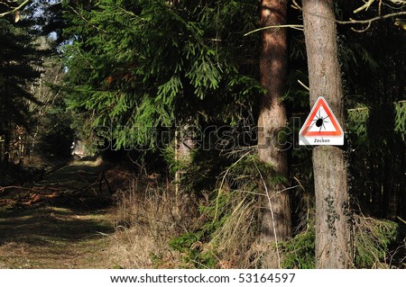 A warning sign referable ticks in wood. Written in german. Royalty-Free Stock Photo #53164597