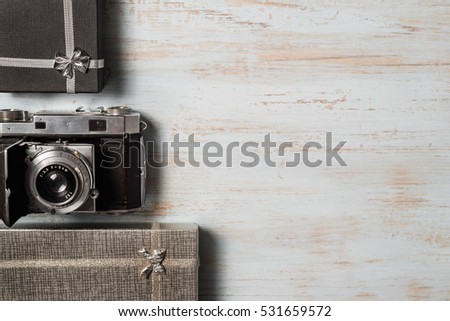 Vintage photo camera on wooden background with gift boxes. top view. copy space