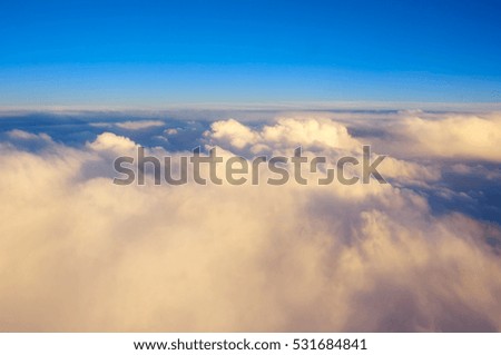 View from aircraft above clouds at sunset as background. Soft focus.