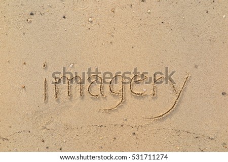 Handwriting words "imagery" on sand of beach