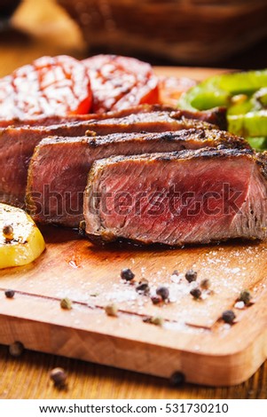 Juicy steak and grilled vegetables with spices Royalty-Free Stock Photo #531730210