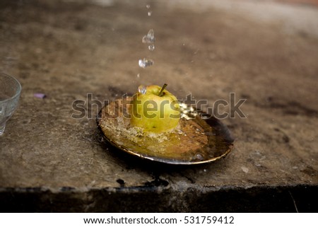 apples in the water stream with splashes standing on the plate outdoors