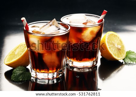 Softdrink with ice cubes, lemon and straw in glass 