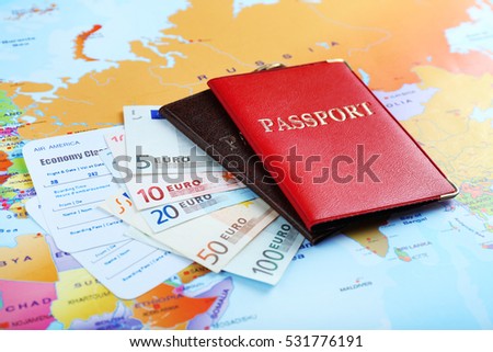 Passports, Euro banknotes and tickets on world map background
