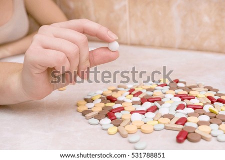 Woman is holding a pill and is about to take it. Coronavirus