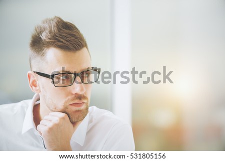 Close up portrait of handsome european businessman in spectacles on blurry city background