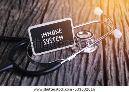 Stethoscope on wood with immune system word as medical concept. Royalty-Free Stock Photo #531832816