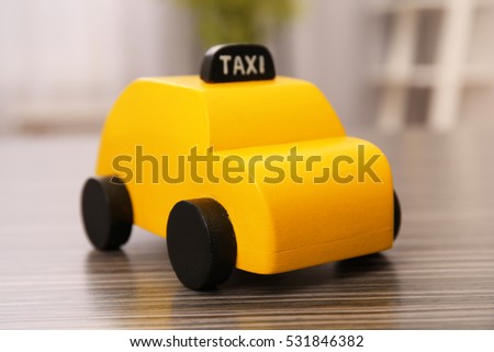 Yellow toy taxi cab on wooden table