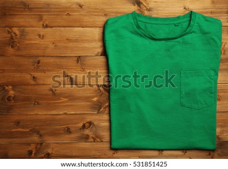 Blank green t-shirt on wooden background