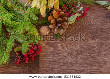 Christmas tree branch with berries on wooden board