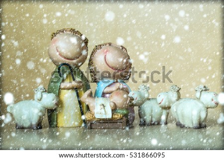 Closeup view of decorative celbrating Christmas and Jesus birth figurines of holy vergin Mary Josepd newborn child with few white sheeps standing on light leather background, horizontal picture
