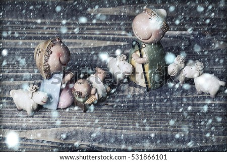 Closeup view of decorative celbrating Christmas and Jesus birth figurines of holy vergin Mary Josepd newborn child with few white sheeps standing on wooden background, horizontal picture