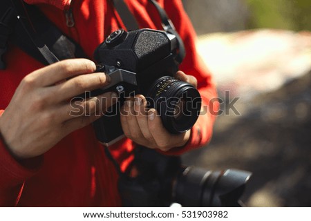 Old camera in the hands of the photographer.