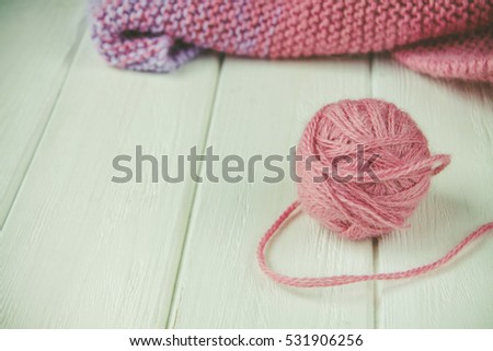 Knitting yarn rolled into ball on a white wooden background.