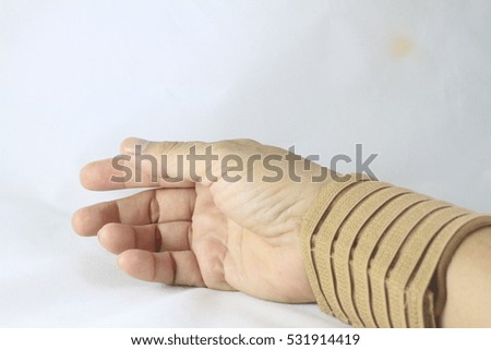 An old woman with wrist pain in an Elastic Bandage isolated on white background