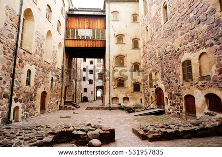 Walk way between building and pattern of windows at Turku castle.  Medieval building in the city of Turku in Finland. It was founded in the late 13th century and stands on the banks of the Aura River Royalty-Free Stock Photo #531957835