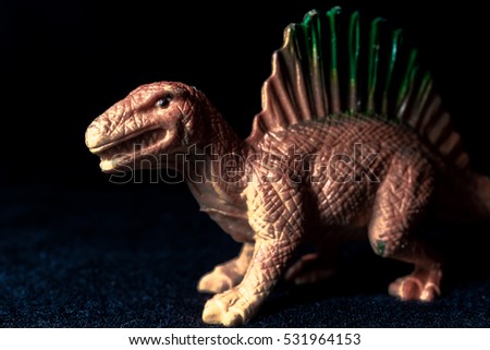 Isolated dinosaur on black background with copy space for texting. Dark tone picture style.
