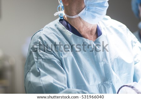 Surgeon in hospital surgery operating theater emergency room in blue doctor's surgical sterile uniform in arthroscopy operation.