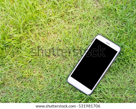 Top view smartphone of black screen showing on grass