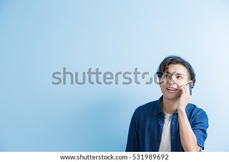 man student talk on phone isolated on blue background,asian