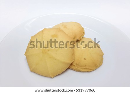 Stack of butter cookies in white plate isolated on white background