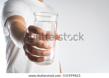 Hand holding a glass of water on white background Royalty-Free Stock Photo #531999823