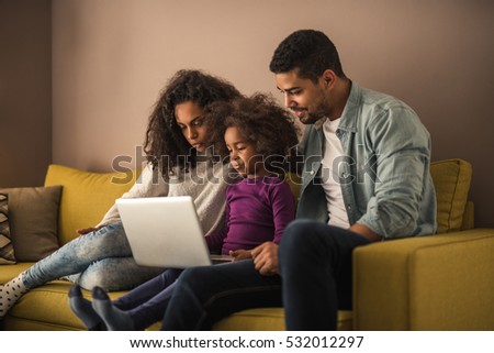 African american family watching cartoons on a laptop.

