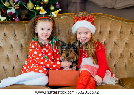 Happy Little girls and dog as their gift at Christmas. Christmas interior