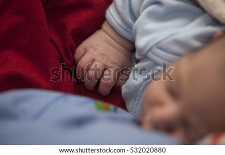 Picture of a newborn baby sleeping on blanket. Selected focus on the hand