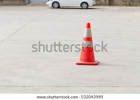 parking lot with traffic cone on street used warning sign on road