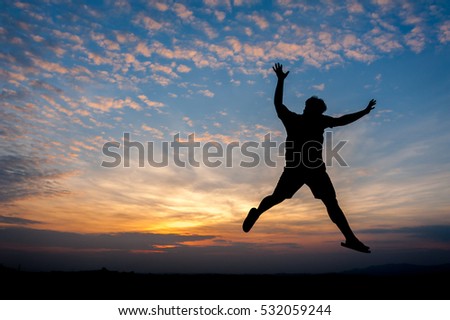 Man jumping Silhouette behind the twilight.