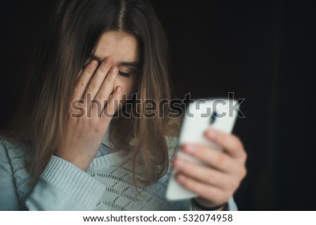 Teen girl excessively sitting at the phone at home. he is a victim of online bullying Stalker social networks Royalty-Free Stock Photo #532074958
