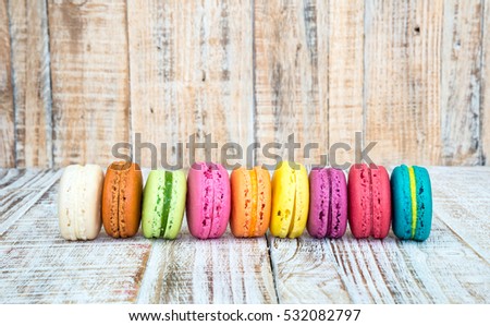 Colorful macarons on vintage pastel background. Macaron or Macaroon is sweet meringue-based confection.
