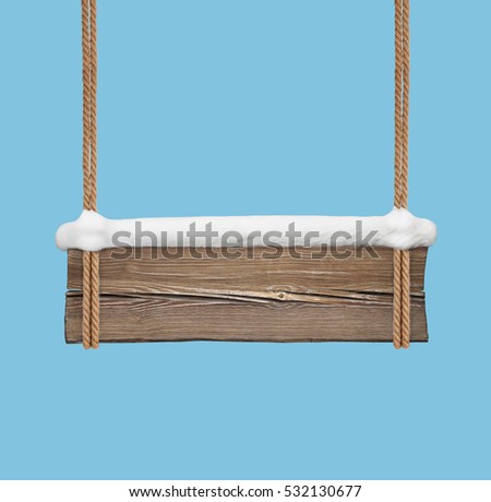 Wide wooden signboard with snow hanging on double ropes on blue background